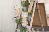 a wedding seating chart with lots of lavender in buckets and a seating plan composed of wooden beams and signs