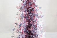 a white wedding cake cut out and with plenty of pink and purple butterflies flying out of it is a lovely and refined idea
