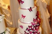 a white wedding cake decorated with lots of purple butterflies and ribbons is a lovely and bold idea that looks fairy-tale-like