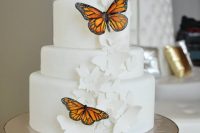 a white wedding cake decorated with white sugar butterflies and bold usual ones is a pretty and chic idea to rock