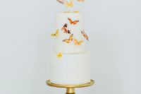a white wedding cake topped with some natural-looking butterflies on wire is a lovely and bold idea that you can realize yourself