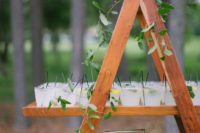 a wooden ladder with greenery and fresh drinks is a cool wedding drink bar for a rustic celebration