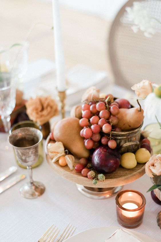 an edible wedding centerpiece of pears, grapes, apricots, berries and candles around is a beautiful idea for a harvest wedding