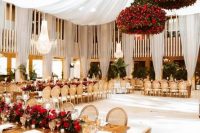 an exquisite Valentine’s Day wedding venue with jaw-dropping red rose chandeliers and a red rose table runner with greenery