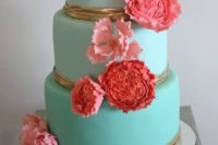 an ombre tiffany blue wedding cake decorated with gold and bright red and pink sugar flowers on top