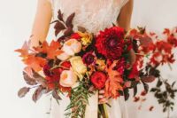 an oversized colorful wedding bouquet with various fall leaves, cascading greenery and bright blooms
