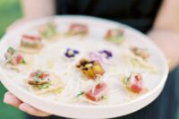 bite-sized tuna pieces on flaky sesame crackers, and top the snacks off with colorful watercress and colorful edible flowers