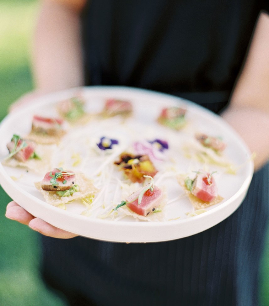 Bite sized tuna pieces on flaky sesame crackers, and top the snacks off with colorful watercress and colorful edible flowers