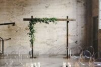candles and greenery to line up the aisle with ghost chairs and a wedding arch decorated with greenery
