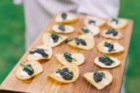 crackers with black caviar, cream cheese and green onions are amazing cocktail hour wedding appetizers