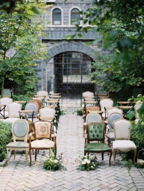 elegant mismatching vintage chairs, greenery and neutral blooms along the aisle are a great combo for a chic wedding outside