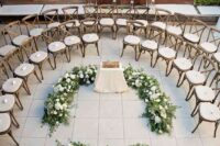 elegant white chairs arranged in circles, white blooms and greenery are a chic and lovely idea for a stylish wedding ceremony