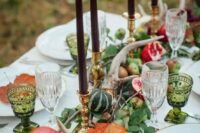 green leaves, pumpkins, pomegranates, antlers and dark candles for a woodland-inspired tablescape