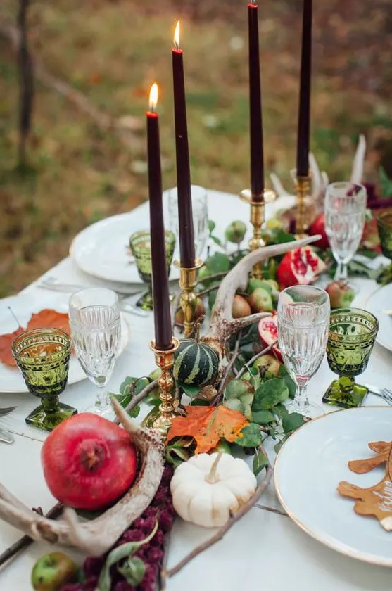 green leaves, pumpkins, pomegranates, antlers and dark candles for a woodland-inspired tablescape