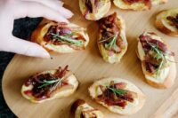 hummus and caramelized onion crostini with soem rosemary on top are a delicious idea