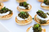 little pancakes topped with cream cheese, caviar and onions are delicious and gorgeous wedding appetizers