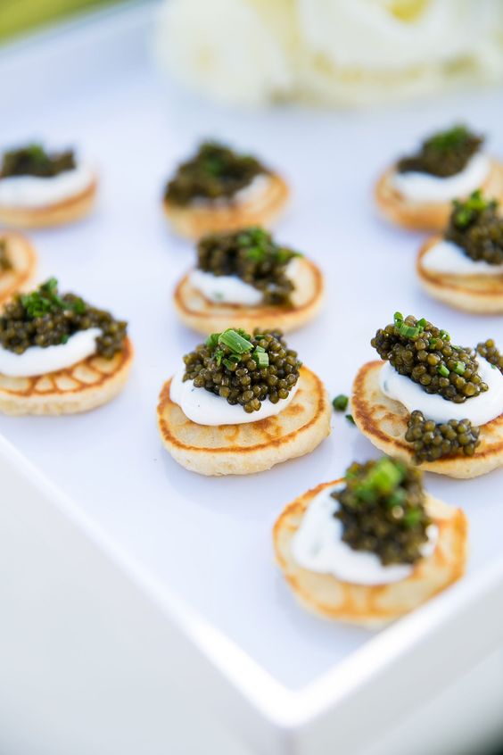 little pancakes topped with cream cheese, caviar and onions are delicious and gorgeous wedding appetizers