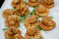 little waffles topped with fried chicken are adorable and crowd-pleasing appetizers for your wedding cocktail hour