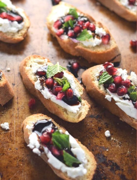 pomegranate and goat cheese crostini with greenery and balsamic are a very refined appetizer idea