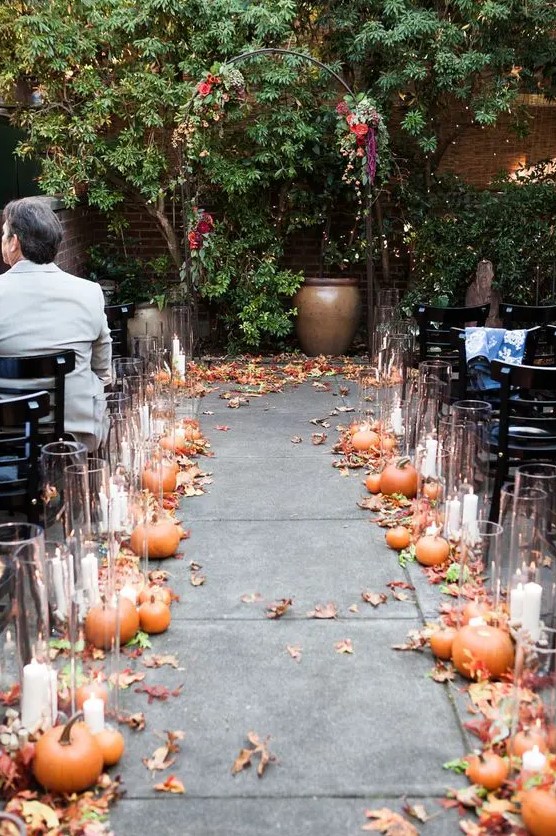 pumpkins, fall leaves and candles in tall candle holders are all that you need to embrace the season