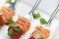 spaghetti and meatballs on forks with greenery is a cool way to serve some meat