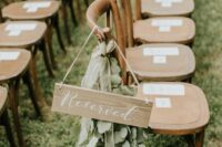 vintage wooden chairs decorated with eucalyptus and wooden signs are great for a rustic wedding