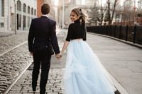 a black turtleneck crop top with short sleeves and a powder blue tulle skirt with a train is a bold modenr bridal look