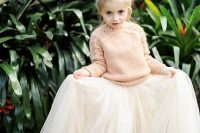 a blush sweater, a white tulle skirt and a top knot for a casual and simple winter flower girl look