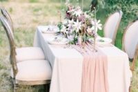 a blush tulle table runner adds a touch of pastel to this beautiful wedding al-fresco dinner