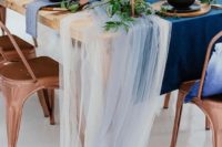 a bold navy table runner and some ivory and light blue tulle that add an airy feel to the table setting