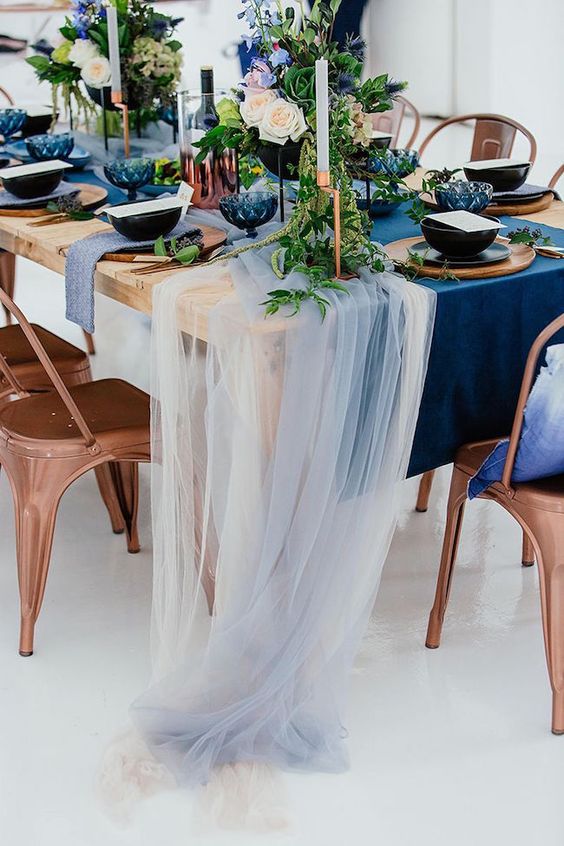 a bold navy table runner and some ivory and light blue tulle that add an airy feel to the table setting