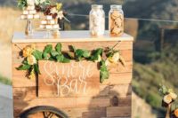 a chic wedding s’more bar with greenery and blooms fully built of pallet wood is a gorgeous option