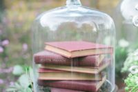 a cloche with book inside is a simple and laconic centerpiece idea, add some greenery around or inside