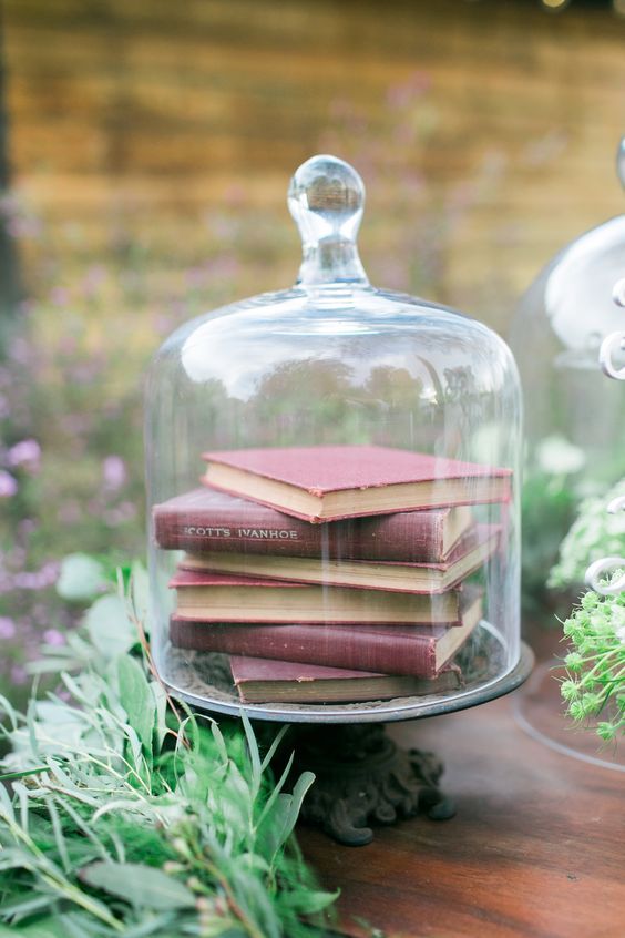 a cloche with book inside is a simple and laconic centerpiece idea, add some greenery around or inside