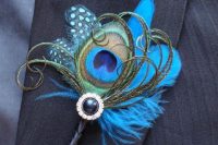 a colorful wedding boutonniere of bright feathers, a button and some yarn is a fun and cool piece
