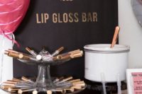 a cool lip gloss bar with a glam sign, some balloons and various lip glosses to try