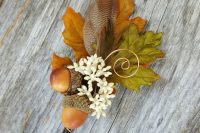 a fall wedding boutonniere of acorns, fall leaves and white blooms is a cool idea for a fall groom or groomsman