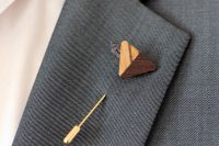 a gold and wood burnt arrow is a cool accessory for a boho-inspired groom’s look