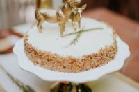 a krispie rice weddig cake with a creamy top, herbs and chic gold deer toppers for a woodland wedding