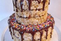 a krispie rice wedding cake with chocolate drip and confetti is a fun party-like idea