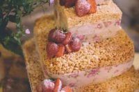 a krispie rice wedding cake with floral ribbons and strawberries on top for a rustic wedding