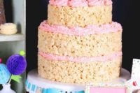 a krispie rice wedding cake with pink cream, confetti and mini pink cones on top