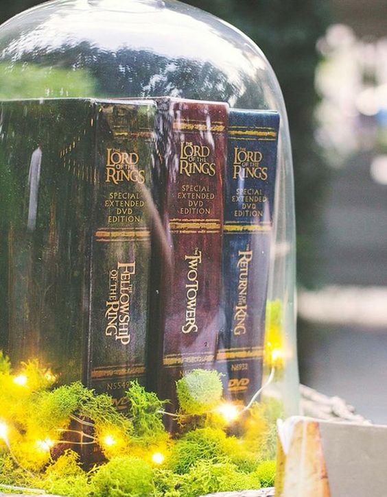 a large cloche with moss, LED lights and LOTR books is a cool idea for a themed wedding