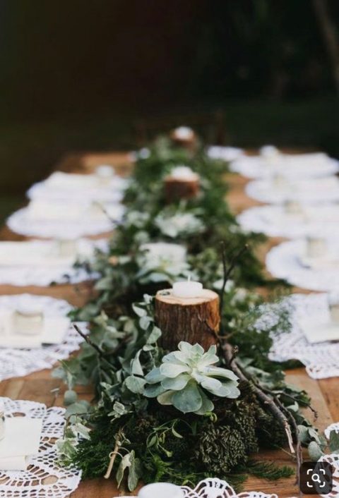 a moss and greenery runner, succulents, greenery, tree stumps with candles and branches will give a natural feel to your table