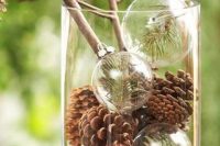a natural winter centerpiece with pinecones and transparent ornaments with fir branches is ideal for winter wedding with a woodland or rustic feel