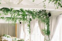 a neutral wedding reception spac with vines climbing up to the beams and ceiling that take over the whole space and make it fresh