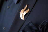a refined gold wedding boutonniere of curves is a bold way to accent a total black look