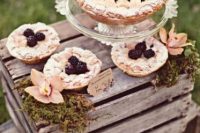 a rustic wedding pie bar with moss, blooms and some delicious pies is all you need for a small wedding