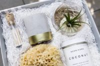 a spa box favor with an air plant, a foam, a candle in a concrete candleholder and some luxurious bath salts