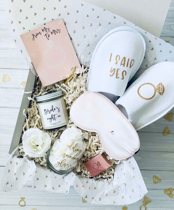 a spa bridal shower gift box with slippers, a jar with bath salts, a sleep mask and a loofah